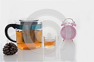 Hot tea set with glass cup and pot on isolated background at tea time